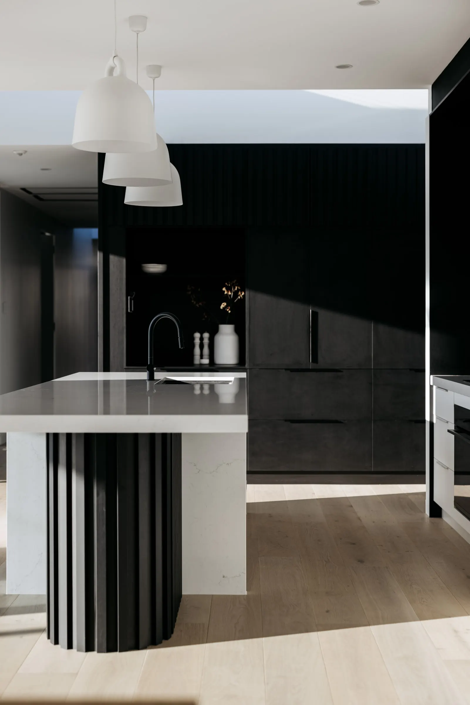 Detail of a fluted white island and dark joinery in a finished kitchen, Launceston