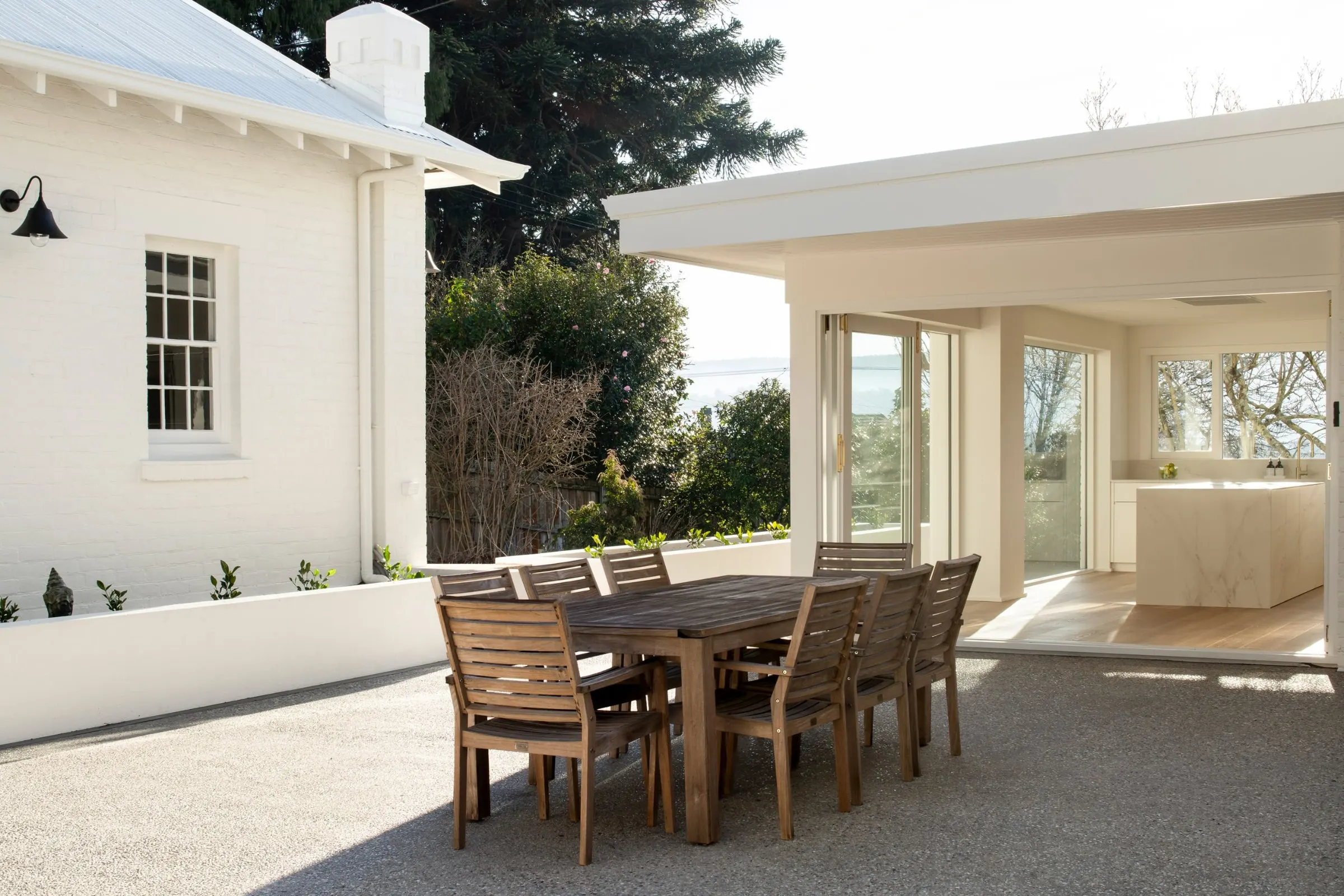 A finished outdoor dining terrace between the original house and the new glazed pavilion, Newstead