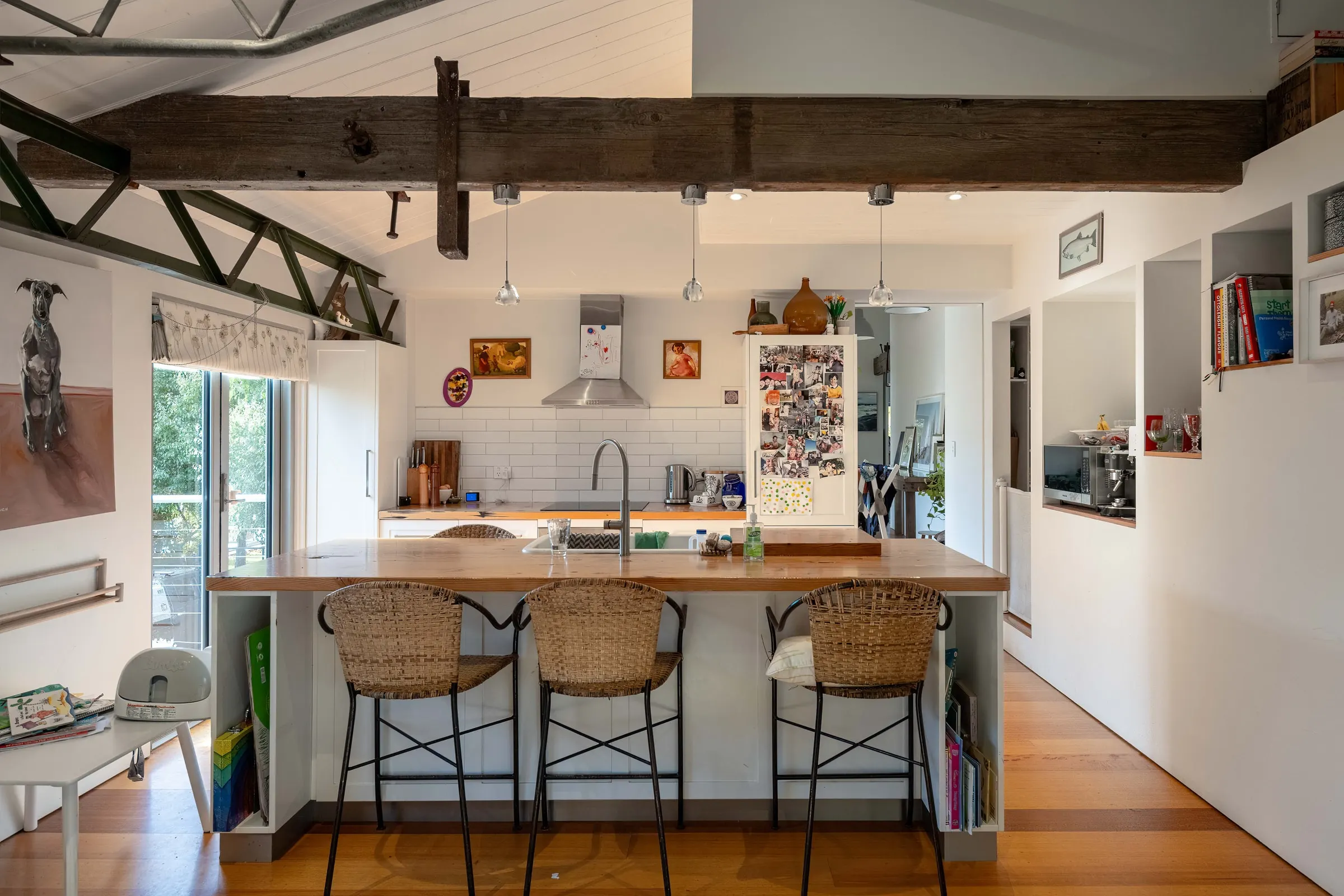 A finished kitchen with exposed timber trusses, a long island and cane stools, Relbia