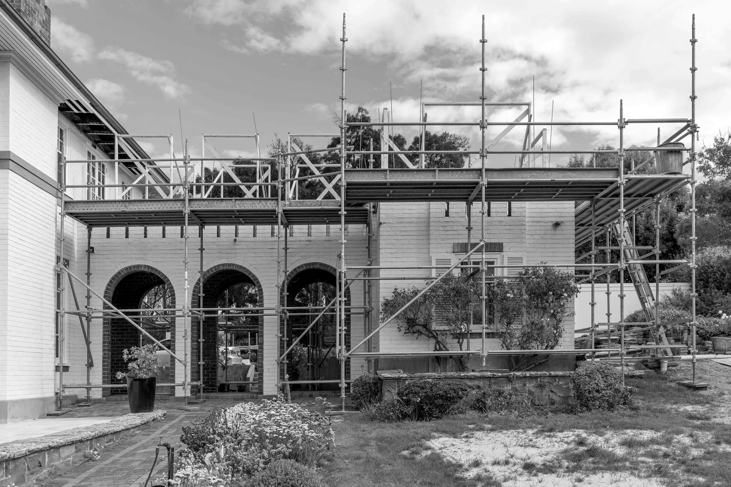 An old house under scaffold, the arched verandah boxed in, East Launceston